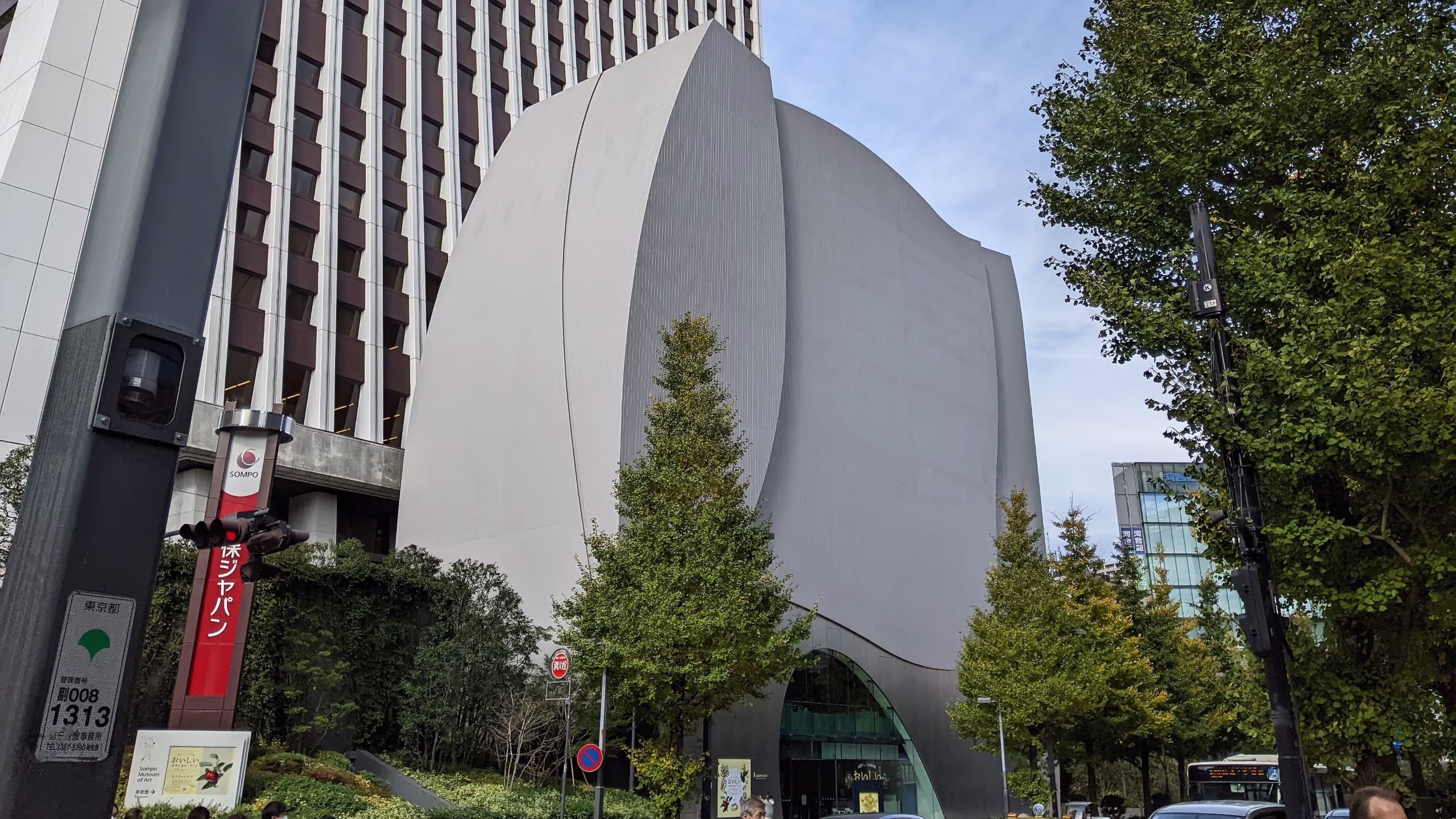灰色で鈍く光り、ゆるやかな曲線で構成された印象的な建物がそびえ立つ