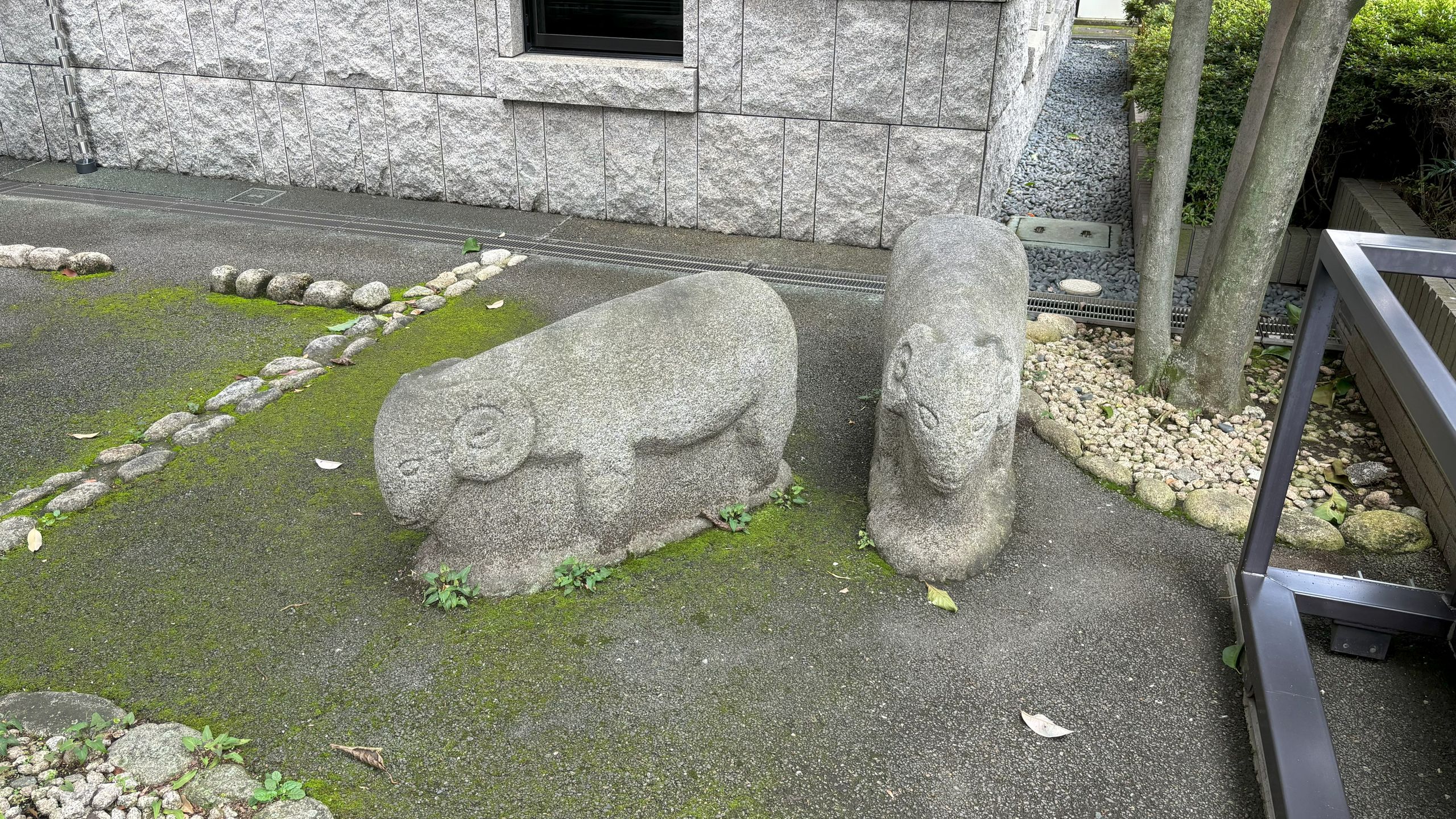 駐車場の隅に石像が2体並んでいる