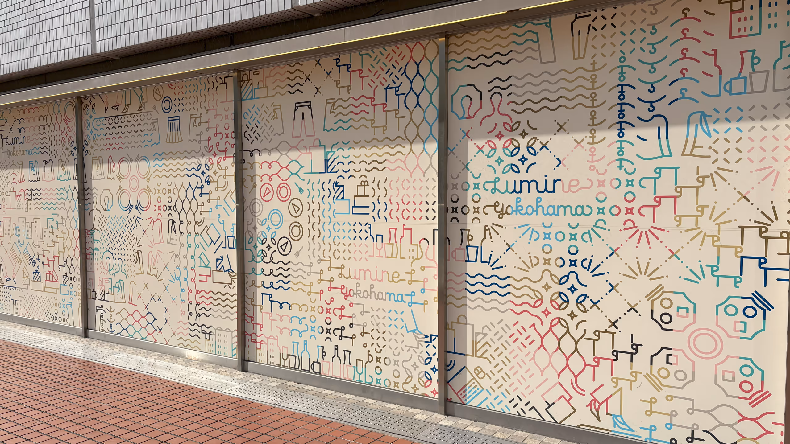 ルミネで扱われている洋服や食料品が、壁面いっぱいにグラデーションのかかったカラフルな線で描かれている。